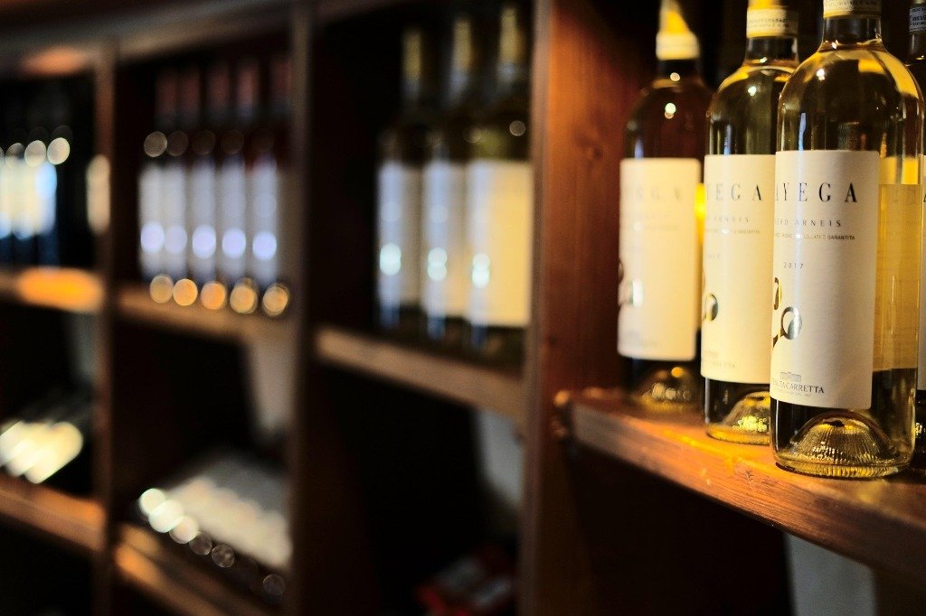 Estate white wine bottles on wooden shelves at Madhuloka Bangalore
